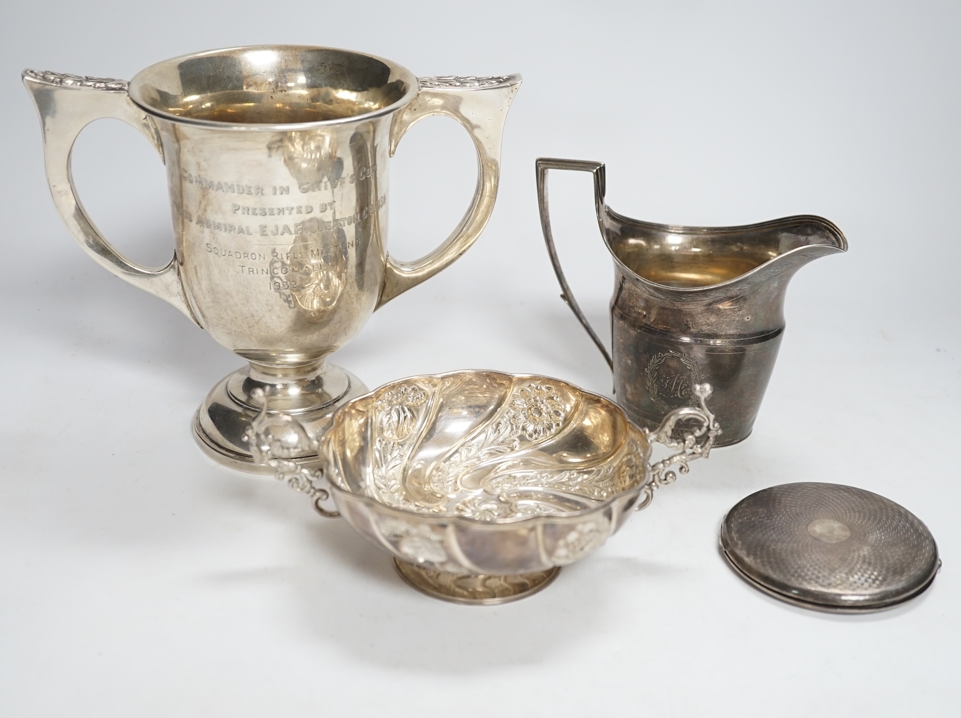 A George III engraved silver helmet shaped cream jug, John Eames, London, 1798, 11.1cm, a Japanese Suzuyo 950 white metal two handled shallow bowl, a George V silver two handled presentation trophy cup and a silver circu